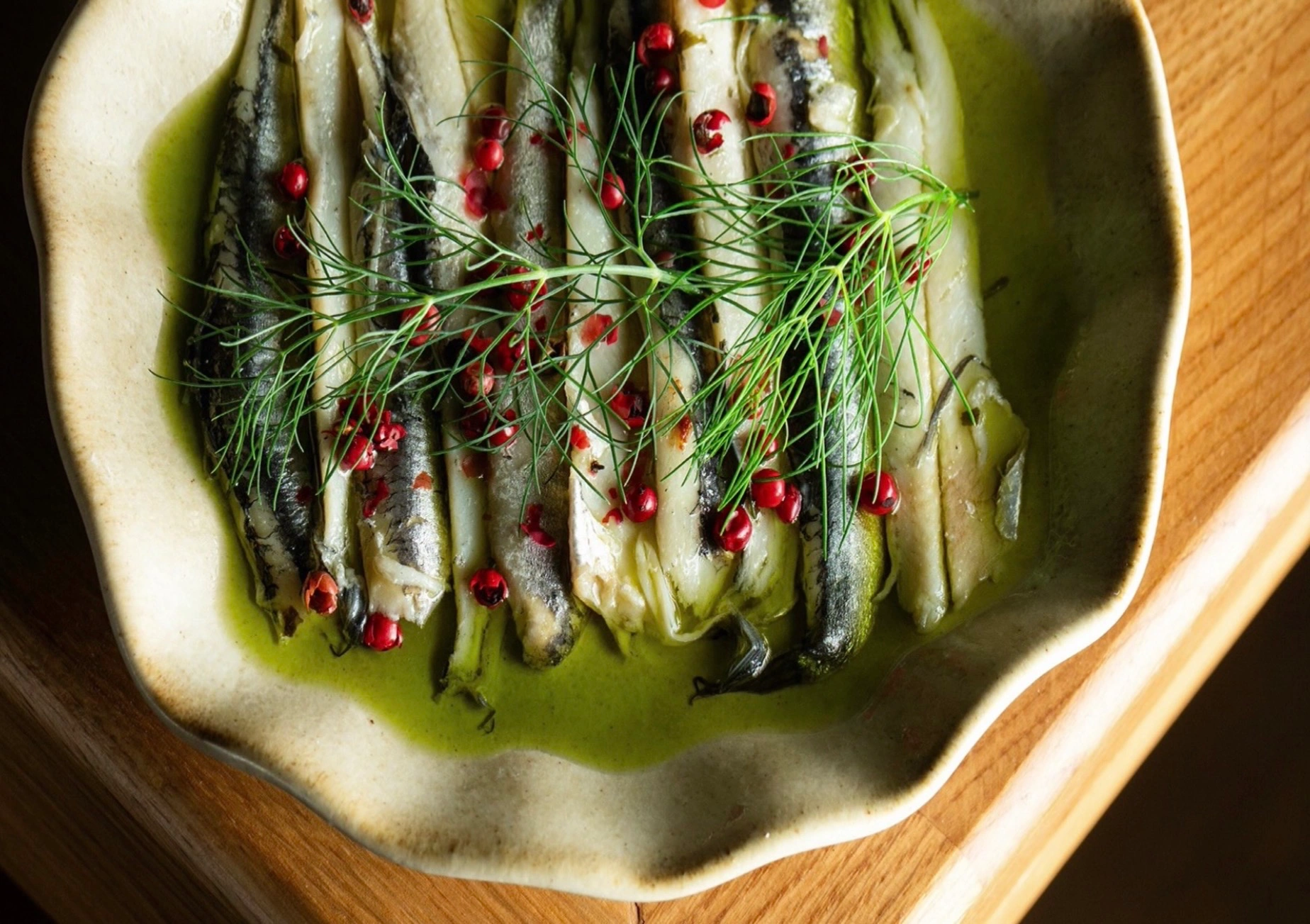 Fischgericht in einer Schale auf einem Holztisch
